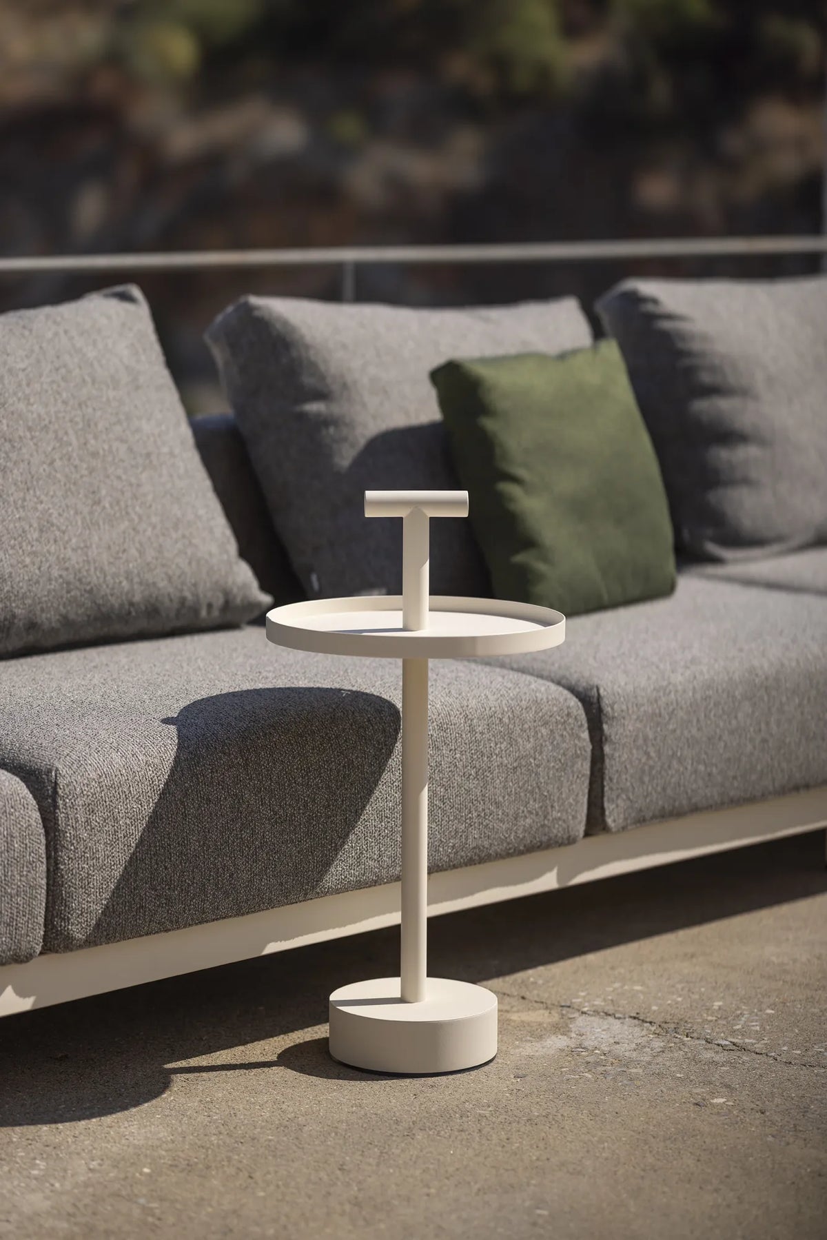 Table d'appoint Albus Todus blanche à côté d'un canapé d'extérieur